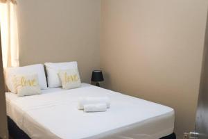 a white bed with two pillows that say love at Casco histórico Demeter in Comayagua