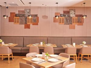 a dining room with wooden tables and chairs at Zenith Hotel-Near Train Station & The Mixc in Xiamen