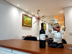 a bottle of wine sitting on a table next to a statue at Apê Novo em Sampa Prox do Tietê Plaza in Sao Paulo