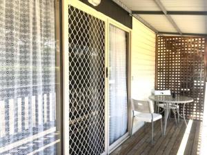 a screened in porch with a table and a glass door at Alexandra Parklife Studio 3 in Alexandra