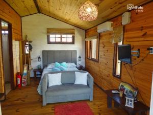 1 dormitorio con cama, sofá y TV en UN SUEÑO LOFT, en Punta del Diablo