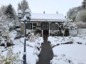 une maison recouverte de neige avec un pôle lumineux dans l'établissement Pickled Pigeon Cottage, à Lawrence