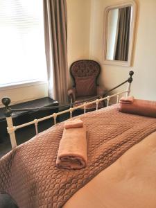 a bed with a blanket and a chair in a bedroom at Pickled Pigeon Cottage in Lawrence