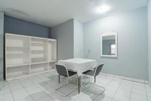 a dining room with a white table and chairs at RedDoorz At Jalan Raya Lembang in Bandung