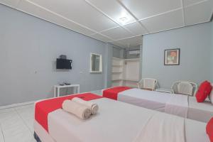 a room with two beds with red and white at RedDoorz At Jalan Raya Lembang in Bandung