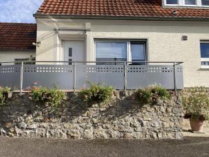 Una casa con una pared de piedra con flores. en Holiday apartment near the Moselle with terrace en Wehr