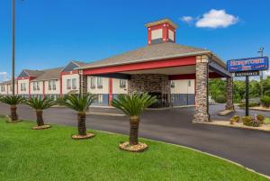 un hotel con palmeras frente a un edificio en Hometown Inn Thomasville, en Thomasville