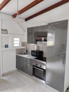 een keuken met een roestvrijstalen koelkast en een magnetron bij Keshy island colibri in Baillif