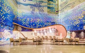 a dining room with tables and chairs and a mural at Sesimbra Oceanfront Hotel - Preferred Hotels and Resorts in Sesimbra