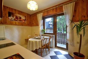 cocina con mesa con sillas y ventana en Muran Apt, en Zakopane