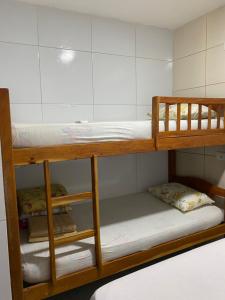 2 Etagenbetten in einem Zimmer mit weißen Wänden in der Unterkunft Apartamento Familiar e aconchegante in Maragogi