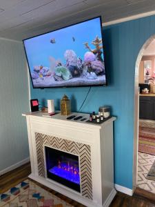 sala de estar con chimenea y TV encima. en Boho-Chic Travel Pad - Unit 2 en Bloomington