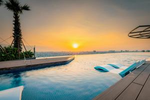 una piscina infinita con vistas al océano al atardecer en La Vela Saigon Hotel en Ho Chi Minh