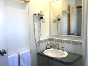 ein Bad mit einem Waschbecken und einem Spiegel in der Unterkunft Alexandra Parklife Studio 4 in Alexandra