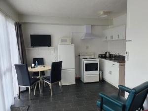 a kitchen with a table and chairs and a refrigerator at Brooklyne Motel Sanson in Sanson