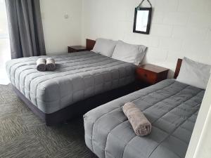 two beds in a bedroom with two pillows at Brooklyne Motel Sanson in Sanson