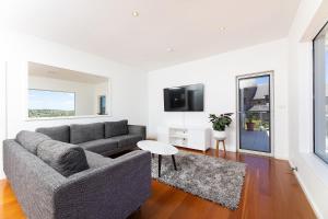 a living room with a couch and a tv at Marine Drive in Forster