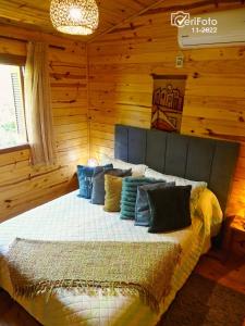 1 dormitorio con 1 cama en una pared de madera en Un Sueño 2, en Punta del Diablo