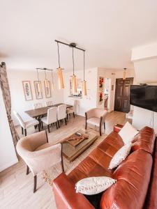 sala de estar con sofá de cuero marrón y mesa en Casa Alicura Pucon en Pucón