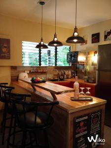 a kitchen with a counter with chairs and a refrigerator at House Rental Banaba Tree in Samboan