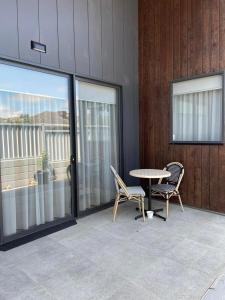 a patio with two chairs and a table and windows at Whittlesea Motel 