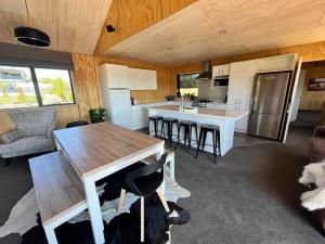 a kitchen and living room with a table and chairs at Wayfarers Lodge in Lake Tekapo