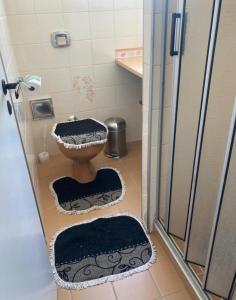 a small bathroom with a toilet and a shower at Apartamento familiar em asturias in Guarujá +8 photos