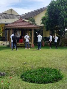 a group of people standing outside of a house at Villa Gazebo Galaxy in Tjiandjur