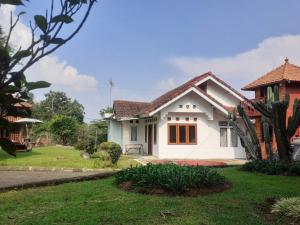 a white house with a green yard at Villa Gazebo Galaxy in Tjiandjur