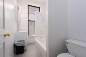 a white bathroom with a toilet and a sink at Midtown East Next to Times Square in New York