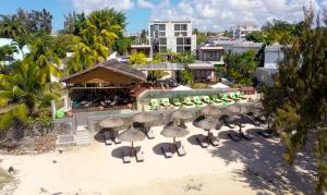 蒙舒瓦西的住宿－Wonders Beach Boutique Hotel，享有带椅子和遮阳伞的度假村的空中景致