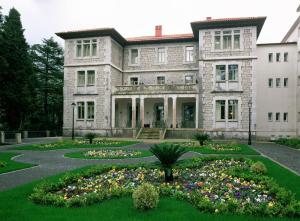 uma grande casa de pedra com um jardim em frente em Parador de Limpias em Limpias