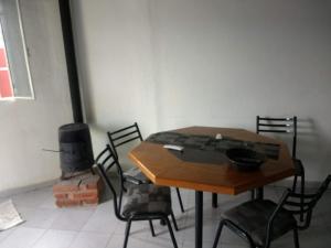 een tafel en stoelen in een kamer met een open haard bij Casa de campo Los Aloe in Cruz del Eje