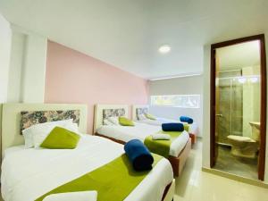 1 dormitorio con 2 camas y baño en Hotel Calantha, en Bogotá