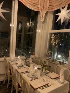 una mesa larga con manteles y servilletas blancos en Hotell Plevnagården, en Malmköping