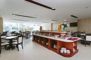 a restaurant with a counter and tables and chairs at Bantique Hotel in Da Nang
