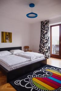 sypialnia z łóżkiem i kolorowym dywanem w obiekcie Zimmer & Appartements in der Gamlitzerstrasse w mieście Ehrenhausen