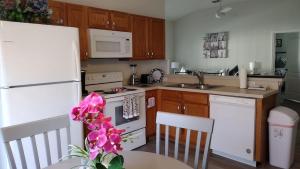 eine Küche mit weißen Geräten und einem Tisch mit rosa Blumen in der Unterkunft Renovated 5 Bed/3 Bath Villa in Davenport