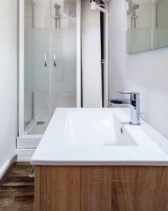 a bathroom with a white sink and a shower at LD-Location Hôtel in Montluçon