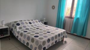 a bedroom with a bed with a polka dot blanket at Mon oasis in Saint-Louis