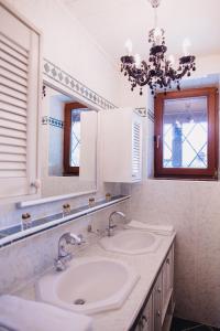 W łazience znajdują się 2 umywalki, lustro i żyrandol. w obiekcie Zimmer & Appartements in der Gamlitzerstrasse w mieście Ehrenhausen +20 zdjęć