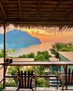 a view of the ocean from a porch with two chairs at Phi Phi Sea Sky Resort in Phi Phi Don