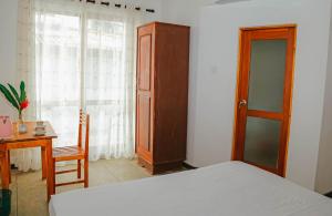 Habaraduwa CentralにあるParadise Beach House - 3 Bedrooms Apartment in Habaraduwaのベッドルーム1室(ベッド1台、デスク、窓付)