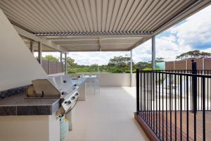 an open kitchen with a counter and a balcony at Aura 10 Shoal Bay in Shoal Bay