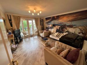 a living room with a couch and a painting of horses at Ideal for country holidays and trips to London's tourist attractions in Hemel Hempstead