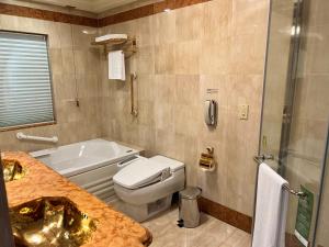 a bathroom with a tub and a toilet and a sink at Evergreen Laurel Hotel Taipei in Taipei