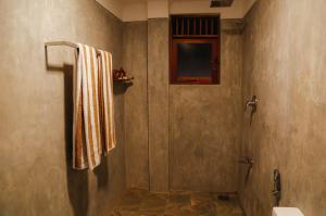a bathroom with a shower with a towel on a wall at Paradise Beach House - 3 Bedrooms Apartment in Habaraduwa in Habaraduwa Central