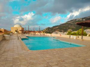 a swimming pool with blue water in a resort at Luxury Apartments Mascarat in Altea