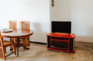 a tv sitting on top of a stand with a table at Paradise Beach House - 3 Bedrooms Apartment in Habaraduwa in Habaraduwa Central