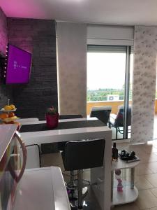 a kitchen with a white counter and some chairs at Apartment Heaven Hill in Jadranovo